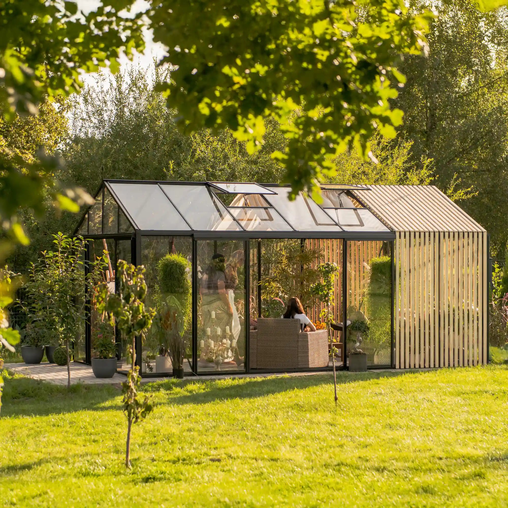 Interior of The Cottage glass greenhouse with couch and plants