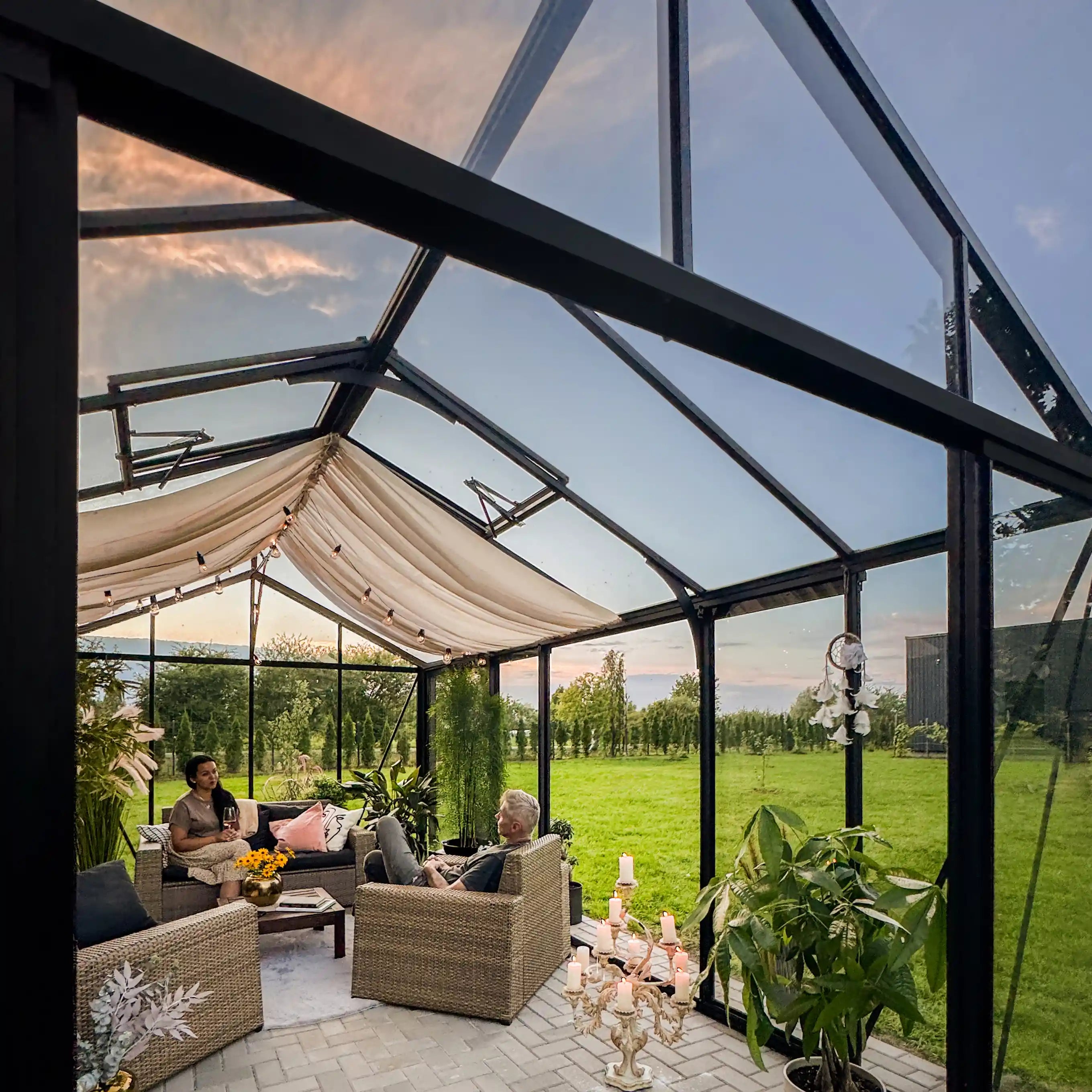 Interior of The Cottage glass greenhouse with couch and plants